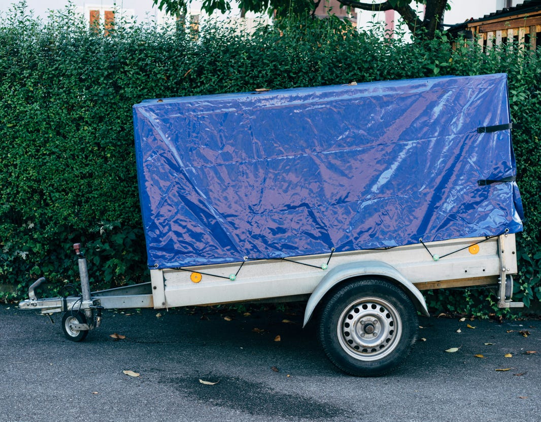 Refrigerated trucks parked in an industrial lot under a clear blue sky on a sunny day.