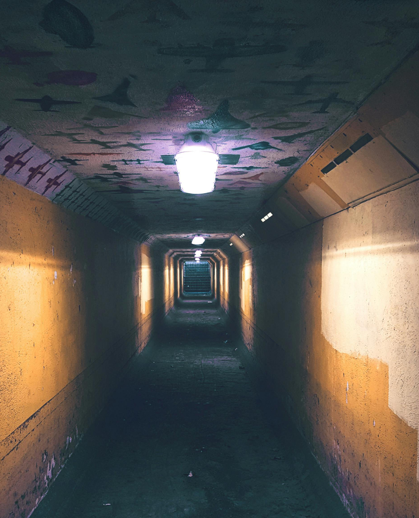 Dimly lit urban tunnel with an eerie and mysterious atmosphere.